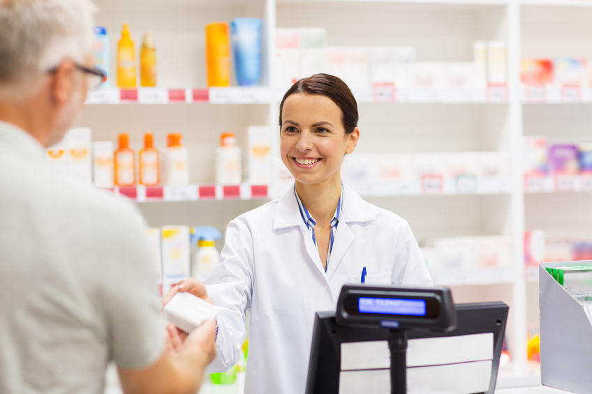 medicine, pharmaceutics, health care and people concept - apothecary and senior man customer buying drug at drugstore